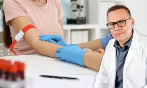 Lekarz w białym kitlu przygotowuje się do pobrania krwi, by zbadać poziom cholesterolu i homocysteiny.