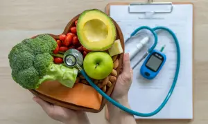 Serce pełne zdrowych produktów: łosoś, brokuły, awokado, jabłko, pomidorki, migdały i ser. Stetoskop i glukometr sugerują dietę glikemiczną.