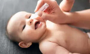 Pomoc mamie w walce z zatkanym nosem u niemowlaka w nocy. Krople do nosa przynoszą ulgę maluszkowi.