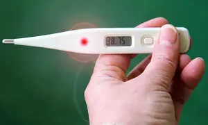 Cyfrowy termometr pokazuje 38.75, wskazując podwyższoną temperaturę człowieka.