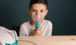 Chłopiec z maseczką inhalatora na twarzy. Czy po inhalacji można wychodzić na dwór?