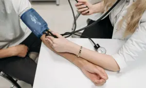 Lekarz dokonuje kalibracji ciśnieniomierza, mierząc ciśnienie pacjentowi.