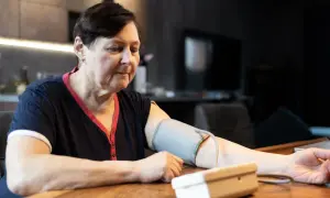 Kobieta mierzy ciśnienie krwi, martwiąc się, jakie ciśnienie krwi jest niebezpieczne.