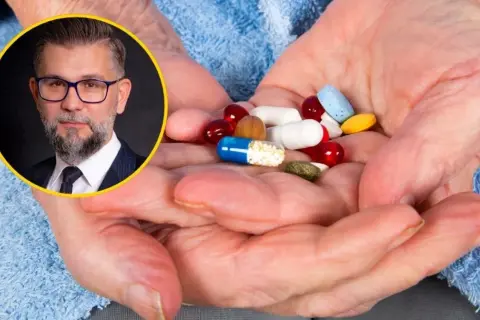 Mężczyzna w okularach i garniturze obok dłoni starszej osoby z garścią tabletek. Czy suplementy diety działają?