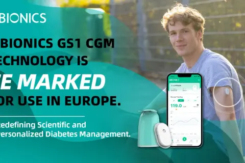 Młody mężczyzna z czujnikiem SIBIONICS GS1 na ramieniu, prezentujący technologię CGM. Aplikacja na telefonie pokazuje dane o glukozie.