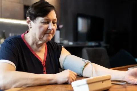 Kobieta mierzy ciśnienie krwi, martwiąc się, jakie ciśnienie krwi jest niebezpieczne.