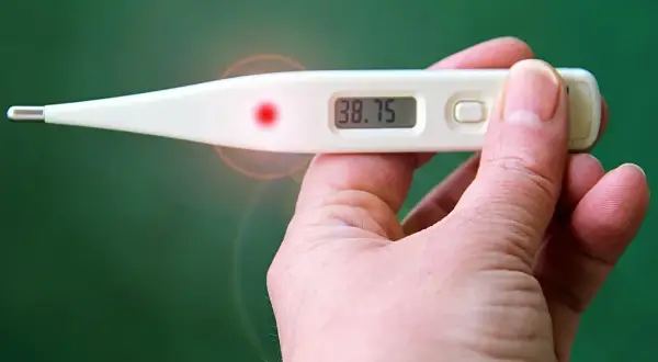 Cyfrowy termometr pokazuje 38.75, wskazując podwyższoną temperaturę człowieka.