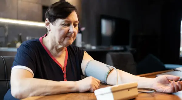 Kobieta mierzy ciśnienie krwi, martwiąc się, jakie ciśnienie krwi jest niebezpieczne.