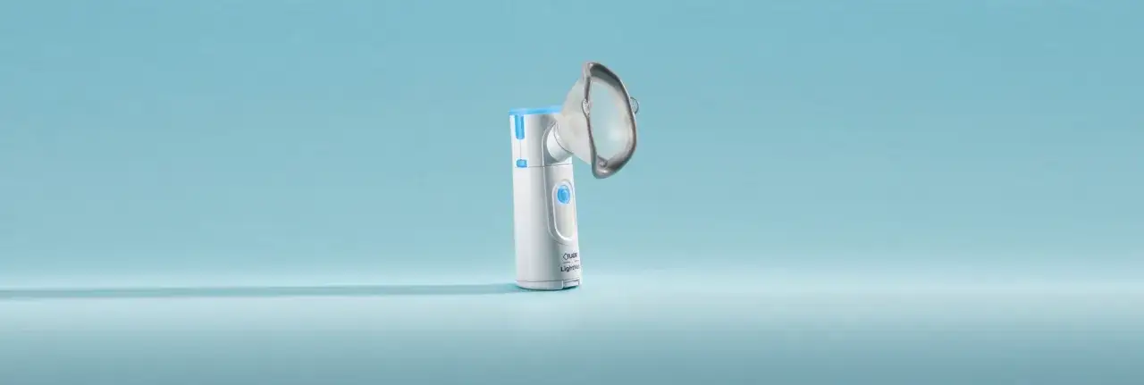 Nowoczesny inhalator na astmę, biały z niebieskimi elementami, gotowy do użycia.