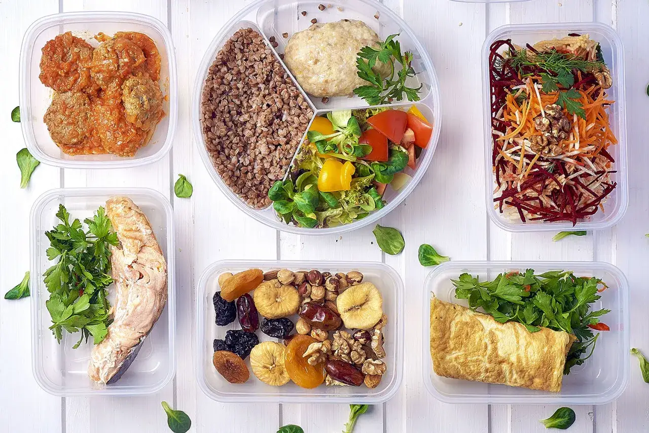 Dieta bezglutenowa co jeść? Pudełka z kaszą, rybą, mięsem, warzywami, jajecznicą i bakaliami.