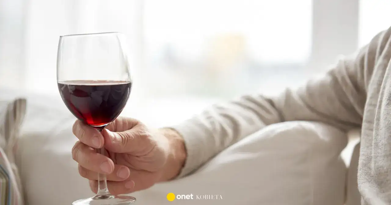 Dłoń trzyma kieliszek czerwonego wina. Zastanawiasz się, czy wino podnosi ciśnienie?