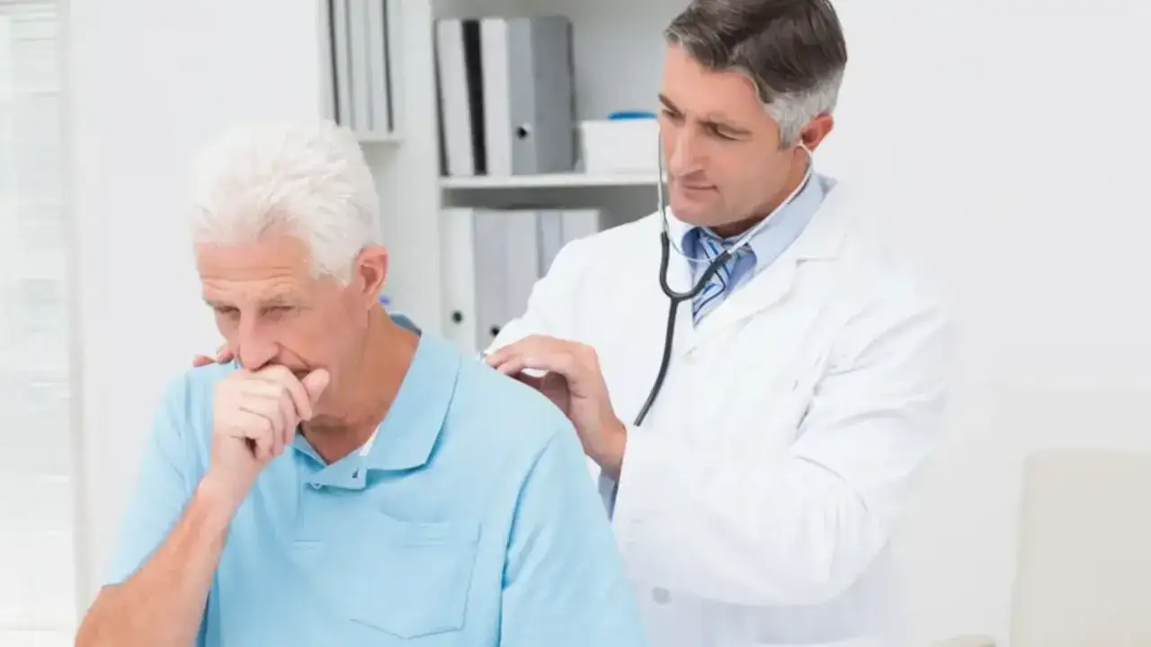 Lekarz osłuchuje pacjenta, który kaszle. To ważny moment, gdy asystor kaszlu może pomóc w diagnozie.