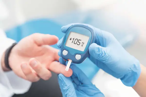 Rękawiczki medyczne i glukometr pokazują wynik 105 mg/dL. Dowiedz się, jak używać glukometru, by monitorować poziom cukru.