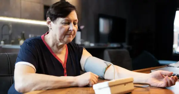Kobieta mierzy ciśnienie krwi, martwiąc się, jakie ciśnienie krwi jest niebezpieczne.